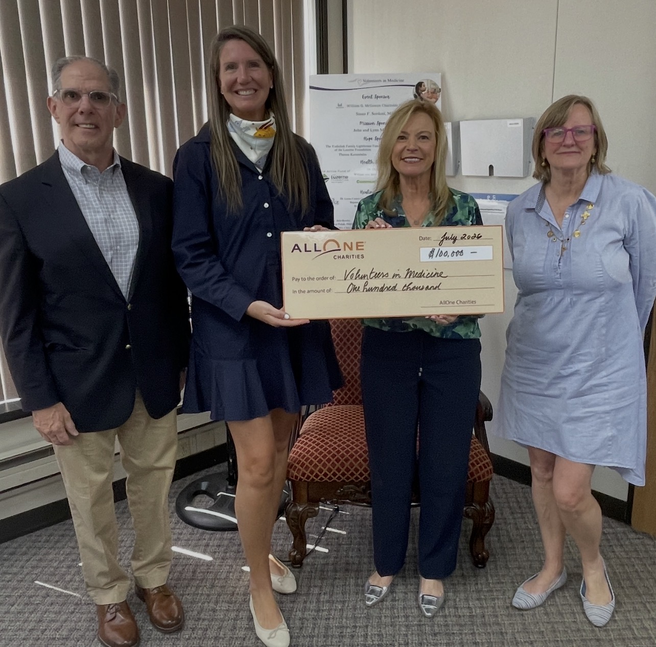 Group holds check for $100,000